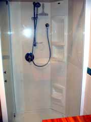 A proprietary formed shower with soap trays and footrests, and safety glass sides.